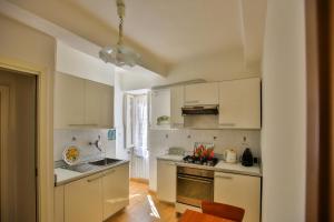 a kitchen with white cabinets and a stove top oven at Affittacamere Anna Michielini in Riomaggiore