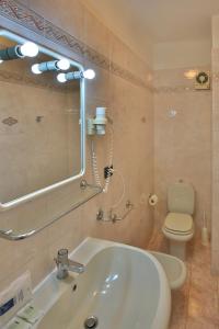 a bathroom with a sink and a toilet and a mirror at Affittacamere Anna Michielini in Riomaggiore +34 photos