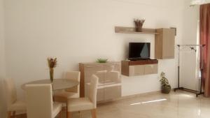 a dining room with a table and a tv at Apartmani Pilić Ljiljana in Brodarica