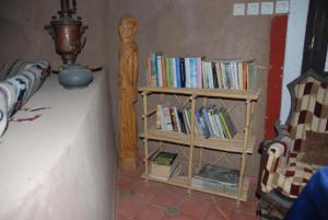 uma estante cheia de livros numa sala em d'hôte Jnane-Dar Diafa em Tamgrout