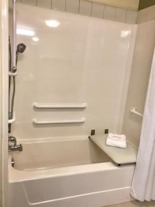 a bathroom with a tub and a shower with a towel at Super 8 by Wyndham Amherst NS in Amherst