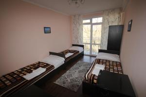 three beds in a room with a window at Parus Hotel in Bosteri