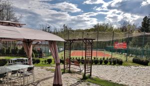 a tennis court with a table and an umbrella at Pensiunea Mirage in Iaşi