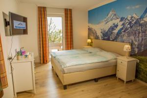 a bedroom with a bed with a mountain mural on the wall at Alpenappartements in Bad Gastein +27 photos