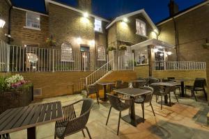 um pátio com mesas e cadeiras em frente a um edifício em The Golden Hope Wetherspoon em Sittingbourne