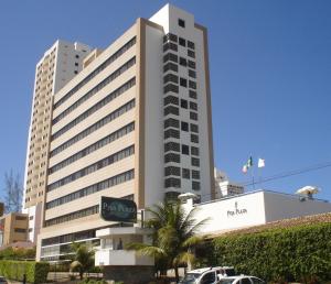 ein großes Gebäude mit davor geparkt in der Unterkunft Pisa Plaza Hotel in Salvador