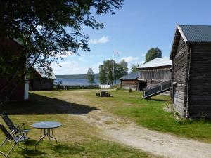 a picnic table next to a barn with a lake at Vestre Sorken Feriegard in Drevsjø