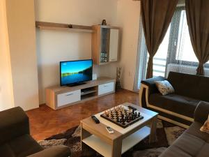 a living room with a television and a chess board on a table at Plitvice Diamond Apartment in Korenica