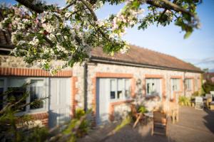 een bakstenen gebouw met witte deuren en een boom bij The Tytherleigh Arms in Axminster