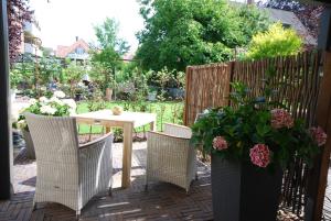 een patio met een tafel en stoelen in een tuin bij Stadthaus Oldenburg in Oldenburg