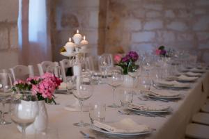 a long table with glasses and flowers and candles at Masseria Valente in Ostuni