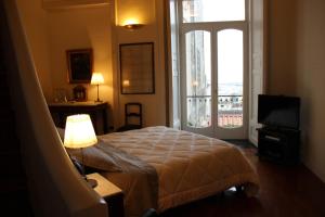 een slaapkamer met een bed, een televisie en een raam bij B&B Palazzo Conforti in Salerno