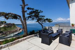 a patio with chairs and a view of the ocean at Apartments Danica in Vrbnik