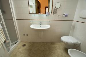 a white toilet sitting next to a sink in a bathroom at Masseria Valente in Ostuni