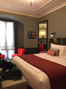 1 dormitorio con 1 cama grande y sillas rojas en Locanda Pandenus en Milán