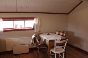 a room with a table and two chairs and a window at Höglunda Gård B&B Lantgård in Skanderåsen