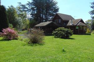 una casa en un campo de césped verde en Saida Room Villarrica, arriendo habitaciones, en Pucón