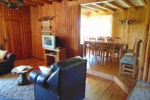 uma sala de estar com um sofá, uma televisão e uma mesa em Saida Room Villarrica, arriendo habitaciones em Pucón
