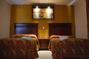 a room with two beds and a painting on the wall at Terracota Corner Rooms in Campeche