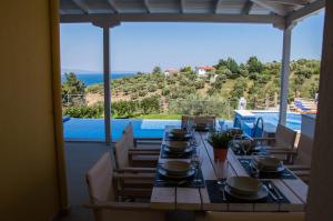 a dining table with a view of a pool at Xalonia Villas in Ayios Nikolaos Sithonia