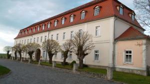a large white building with a red roof at Domäne-Badetz in Badetz