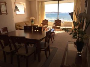 sala de estar con mesa y sillas y vistas al océano en Apartamento en San Alfonso del Mar 3D-2B en Algarrobo