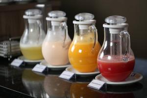 a group of four bottles of juice on a table at Regis Hotel I in Registro