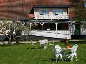 eine Gruppe von Stühlen und Tischen auf einem Hof mit einem Haus in der Unterkunft Onkel Enkels Pensionat in Tomelilla