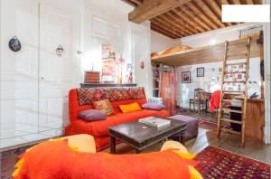 a living room with a red couch and a table at Salon et mezzanine Lyon centre in Lyon