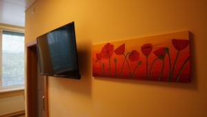 イムストにあるFerienwohnung Imstの赤い花の絵画を描いた壁掛けテレビ