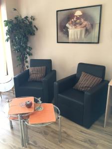 - un salon avec deux chaises bleues et une table dans l'établissement Master Apartments, à Belgrade
