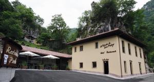 un edificio con una montaña en el fondo en Hotel Rural - El Rincón de Don Pelayo, en Covadonga