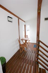 Pokój ze stołem i krzesłami na drewnianej podłodze w obiekcie Sunset Apartments w Hajduszoboszlo