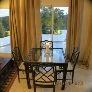 een glazen tafel en stoelen met een kaars erop bij Apartamento del paraiso in Estepona