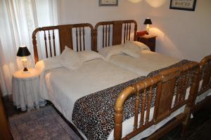 um quarto com uma cama de madeira e 2 mesas de cabeceira em Casona de Treviño em Cosgaya