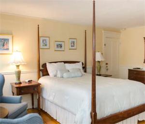 1 dormitorio con 1 cama grande y 1 silla azul en Ashley Inn en Edgartown