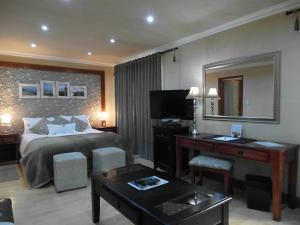 a hotel room with a bed and a desk and a mirror at 2 Leafed Doors in Johannesburg