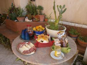 a table with plates of food on it with plants at Salvone's house B&B in Giardini Naxos