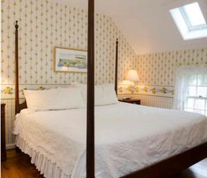 a large white bed sitting in a bedroom next to a window at Ashley Inn in Edgartown