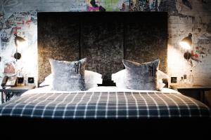 a bedroom with a bed with blue and white sheets and pillows at Malmaison Glasgow in Glasgow