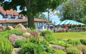 a garden in front of a house with a tent at Highlands Four Season Resort in Calabogie