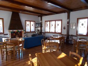 a restaurant with wooden tables and chairs and a blue couch at Albergo Del Sole in Roccaraso