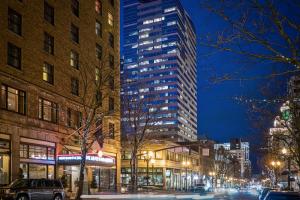 a city street at night with a tall building at Heathman Hotel in Portland