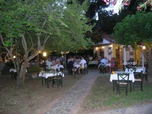 a group of people sitting at tables in a restaurant at Strophilia Apartments in Koukounaries