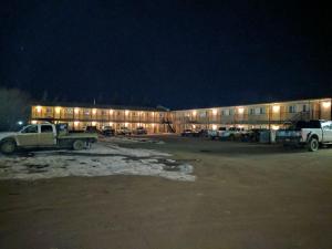 a parking lot in front of a building at night at Aspen Motor Inn in Drayton Valley