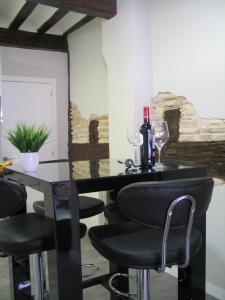 un bar con sillas negras y botellas de vino en una mesa en Apartamento Portales en Logroño