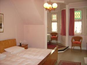 a bedroom with a bed and two chairs and a table at Pension Haus Weller in Boppard