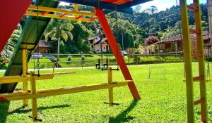 um parque infantil com um baloiço num parque em Pousada Rosa em Gramado