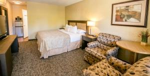 a hotel room with a bed and a table and chairs at Crystal Springs Lodge in Radium Hot Springs