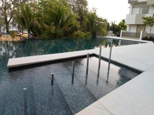 a swimming pool in the middle of a building at By The Sea at Batu Ferringhi Penang in Batu Ferringhi